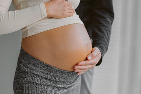 Couple expecting child baby bump man caressing pregnant woman stomach during pregnancy. Maternity shootの写真素材