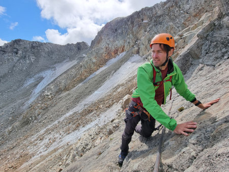 Via Ferrata mountain hike climber man climbing on steep rock in Whistler, BC, Canada travel...