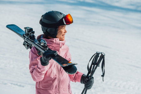 Skiing. Skier woman athlete going skiing on slope ski piste wearing helmet and ski goggles in winter nature landscape. Winter sports active lifestyleの写真素材