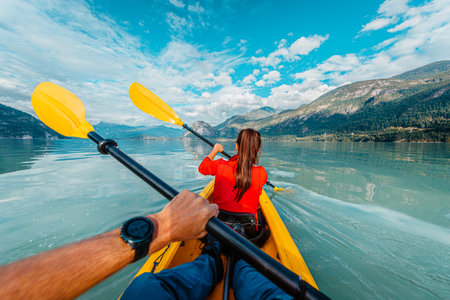 People kayaking paddling in kayak amazing nature landscape in Squamish Howe Sound a fjord surrounded by mountains. People living healthy active outdoor lifestyle in British Columbia, Canada.の写真素材