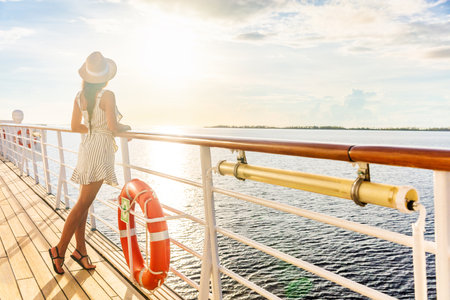 Luxury cruise ship travel elegant tourist woman watching sunset on balcony deck of Europe mediterranean cruising destination. Summer vacation cruiseship sailing away on holiday.の写真素材