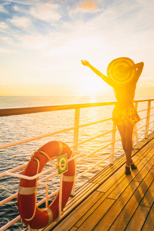 Cruise ship vacation woman enjoying travel vacation at sea. Free carefree happy girl looking at ocean with open arms in freedom pose.の写真素材