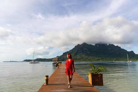 Bora Bora, Tahiti, French Polynesia Travel woman walking on beach smiling in sundress and sunhat on Matira Beach. Image is unretouched and model is without makeup. Real people. Raw Imageの写真素材