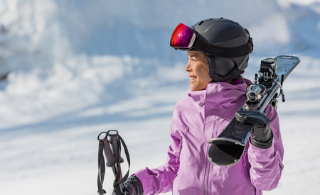 Skiing woman portrait. Skier woman athlete going skiing on slope ski piste wearing helmet and ski goggles in winter nature landscape. Winter sports active lifestyleの写真素材