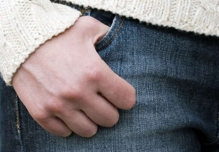 Person with their thumb resting in the pocket of a pair of denim jeans.の写真素材