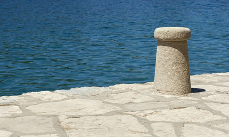 Mooring post on the pier by blue sea.の写真素材