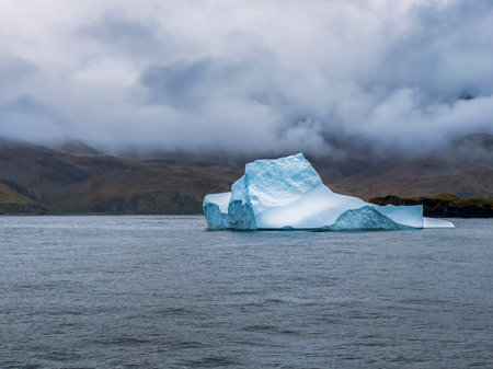 Antarctic iceberg and storm clouds at Stromness Harbour on South Georgia Island in Antarcticaの写真素材