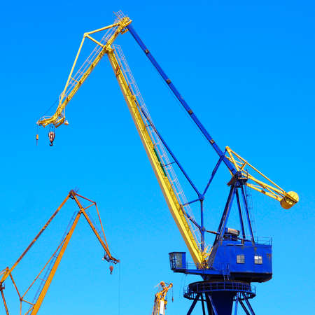 beautiful yellow naval cranes, standing out against the azure blue sky of the port of Piraeus, near...