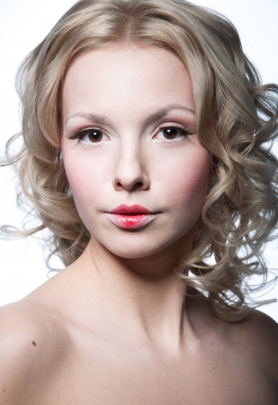 Glamour portrait of beautiful blond woman model with fresh daily makeup, romantic curly hairstyle,shoulders. Isolated on whiteの写真素材