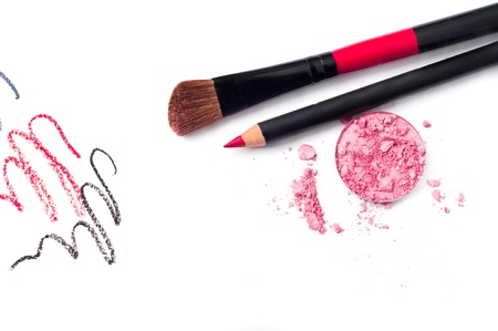 Still life of a small makeup kit light tender pink eyeshadow, red lip pencil, special professional brush for eye shadow applying, red, black and gray pencil strokes  Isolated on white background, copy spaceの写真素材