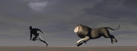 A man runs away pursued by a lionの写真素材