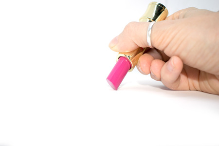 Photo of pink lipstick. In the hand of the girl on a white background.の写真素材