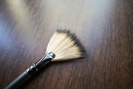 Cosmetic brush photo. Lies on a wooden background. Brush for powder.の写真素材