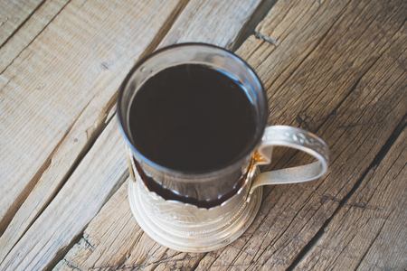 Tea in an old Russian cup holder on a wooden background.の写真素材