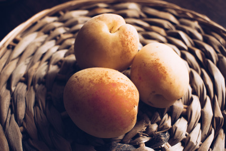 Photo of apricots. On a wicker surface. Summer fruits.の写真素材