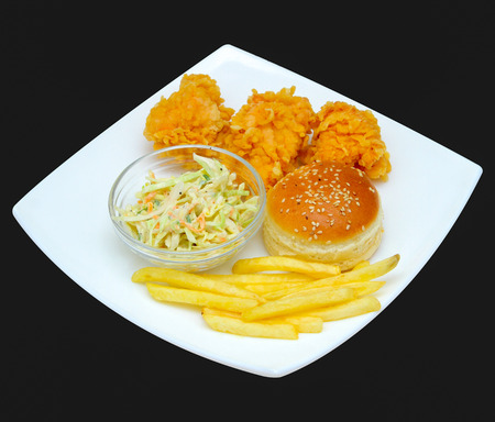 Chicken nuggets with french fries, greens on a plate. On a dark background.の写真素材