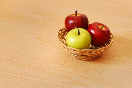 Two red and one green apples in a basketの写真素材