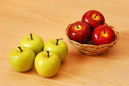Three red apples in a basket with green applesの写真素材