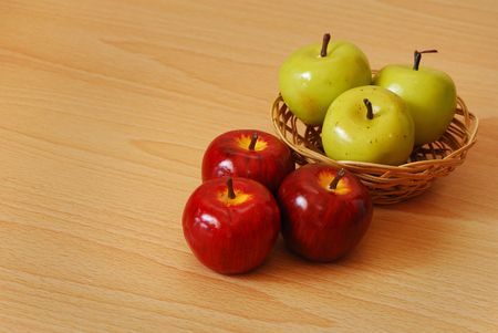 Three green apples in a basket with red applesの写真素材