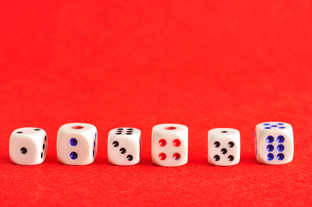A collection of dice on a red backgroundの写真素材