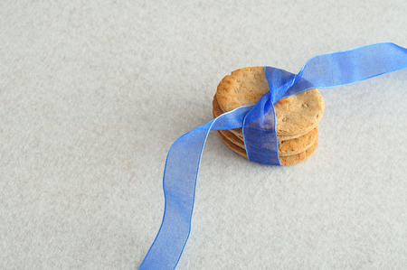 A stack of dog biscuits tied together with a blue ribbonの写真素材