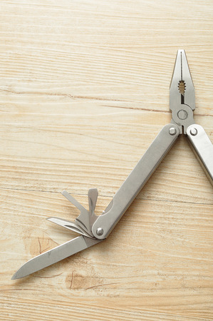 A multifunction tool isolated on a wooden background