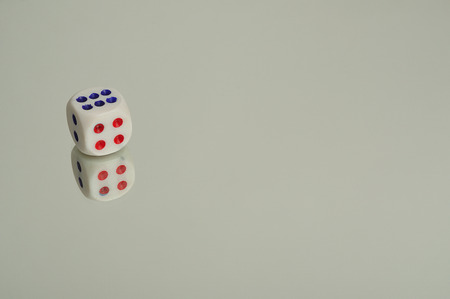 A  dice that is reflection onto a white background