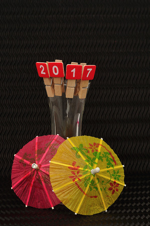 2017 spelled with red blocks displayed on the rim of a shooter glass with a red and yellow  cocktail...