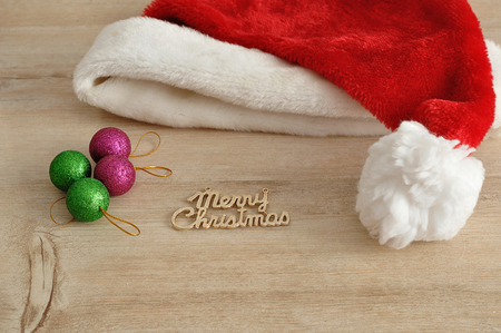 Santa's hat with green and pink baubles with Merry Christmas