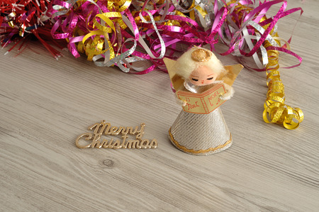 An angel to decorate a Christmas tree with tinsel in the backgroundの写真素材