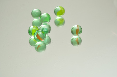 A collection of marbles reflecting into a white backgroundの写真素材