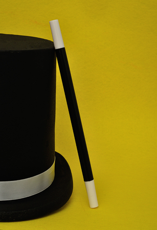 A magicians wand and hat isolated on a yellow backgroundの写真素材