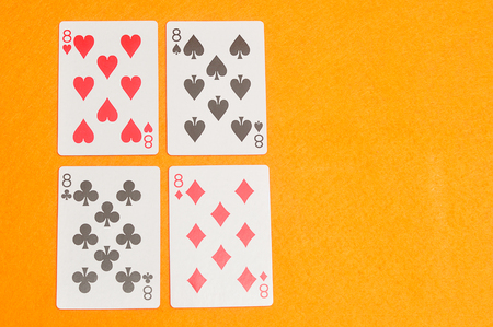 The different suit of the number 8 cards in a deck of cards displayed on an orange background