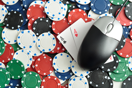 A computer mouse with poker chips and 2 ace cards symbolizing on line pokerの写真素材