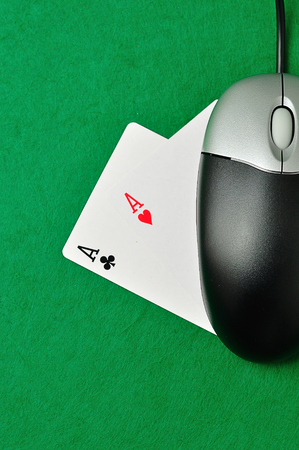 A computer mouse with 2 ace cards symbolizing on line pokerの写真素材