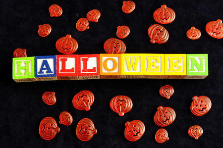 Halloween spelled with alphabet blocks with pumpkins against a black backgroundの写真素材