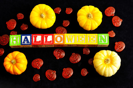 Halloween spelled with alphabet blocks with pumpkins against a black backgroundの写真素材