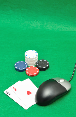 A computer mouse with poker chips and playing cards symbolizing on line pokerの写真素材