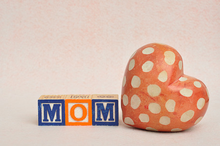 The word mom spelled with alphabet blocks with a heartの写真素材