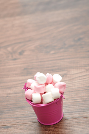Pink and white marshmallows in a pink containerの写真素材