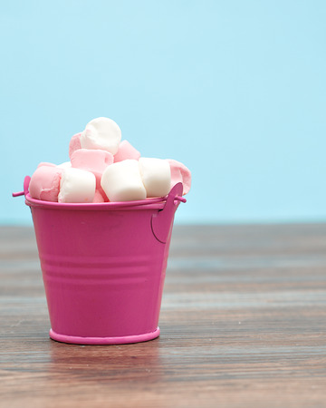 Pink and white marshmallows in a pink containerの写真素材