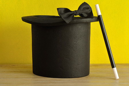 A magicians hat displayed with a wand and bow tieの写真素材