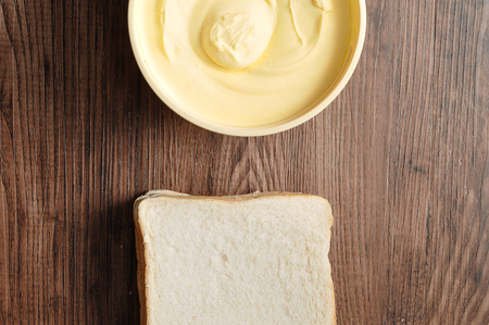 Butter and bread isolated on a wooden backgroundの写真素材