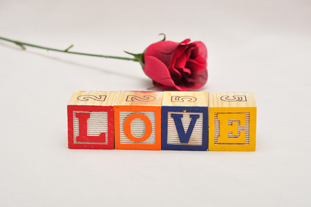 Valentine's Day.Love Spelled with colorful alphabet blocks and a red roseの写真素材