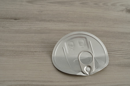 A tin lid isolated on a wooden table