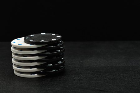 White and black poker chips on a black backgroundの写真素材
