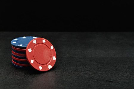 Blue and red poker chips on a black backgroundの写真素材