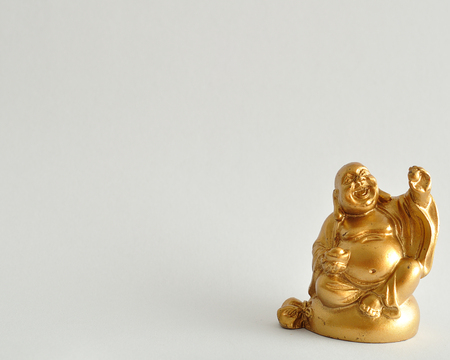 Figurine of a laughing and cheerful golden Buddhaの写真素材