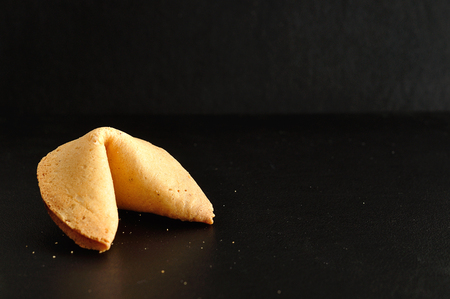 A fortune cookie isolated on a black backgroundの写真素材