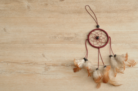 A dream catcher isolated on a wooden backgroundの写真素材